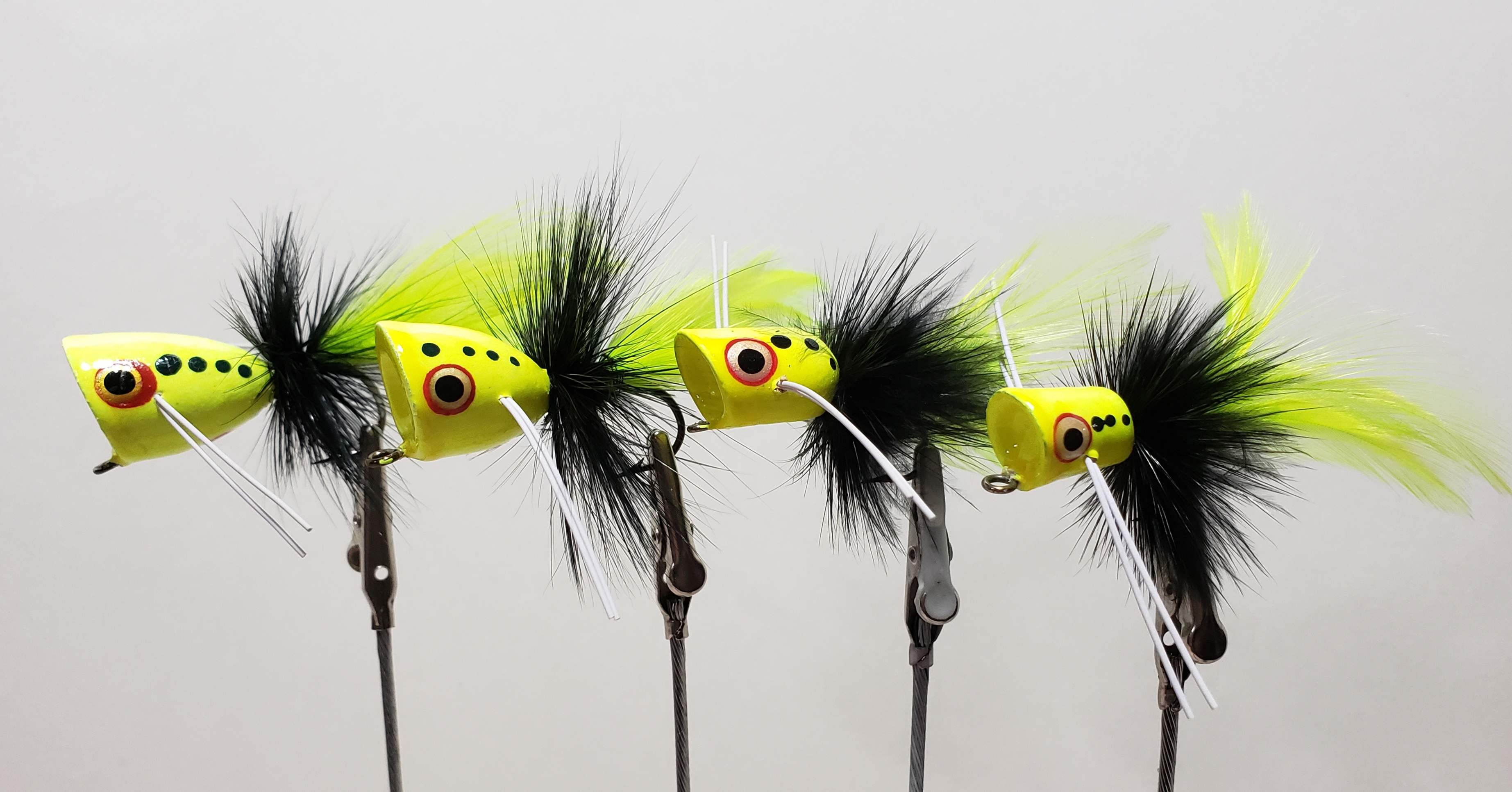 Four Peck’s #7016 poppers with chartreuse bodies and tails and black hackle